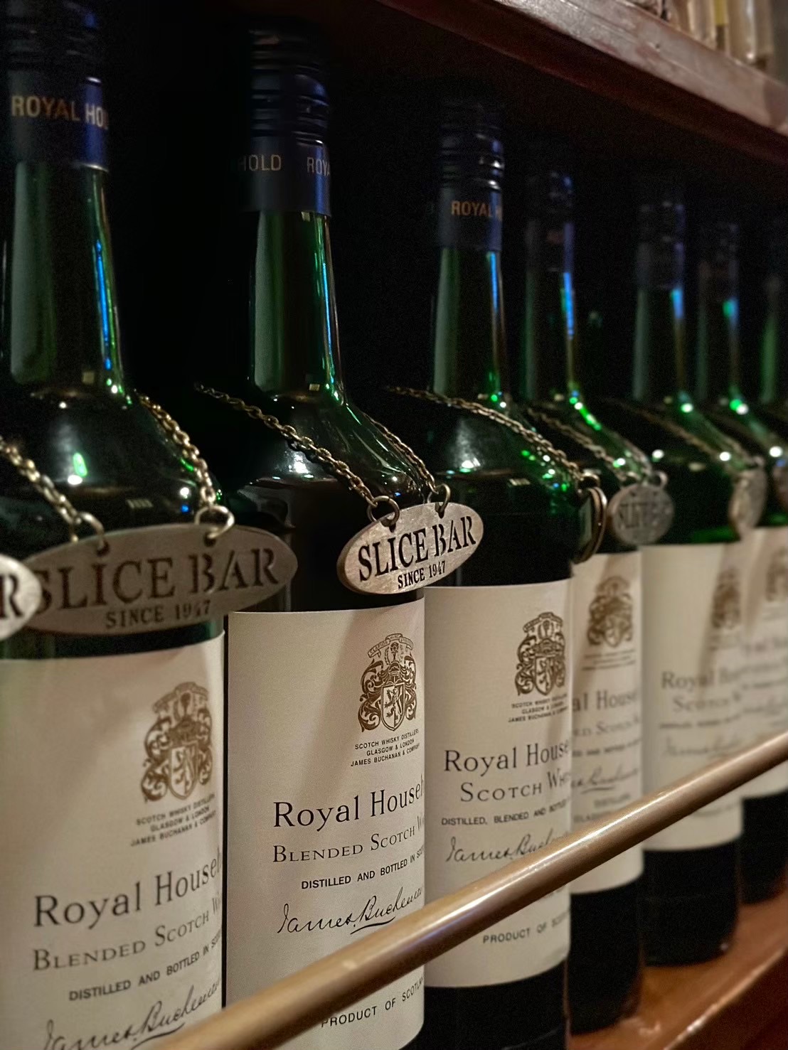 SLICE BARのカウンター席 — 重厚な木材と琥珀色の灯りが映える歴史あるバースペース